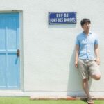 フランスの街角で待ち合わせ場所に早く来てしまい待ちぼうけする男性