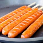 炭火の上で焼き色がつくバーベキューのフランクフルト