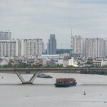 ベトナムのサイゴン川を渡る貨物船と都市風景