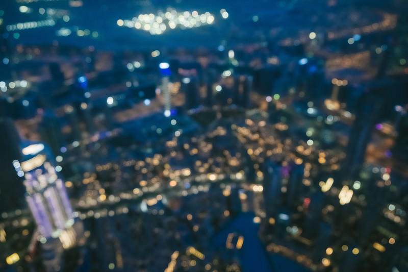 高層ビルからのドバイの夜景、光の玉ボケが幻の街を照らす