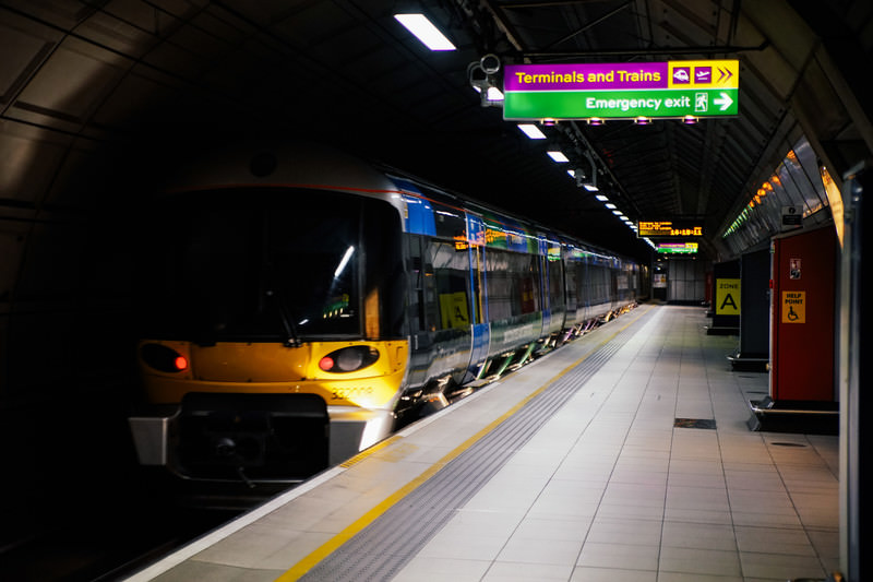 ロンドンの地下鉄駅のホームに停車する空港列車